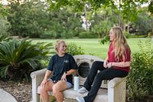 students chatting at a park bench